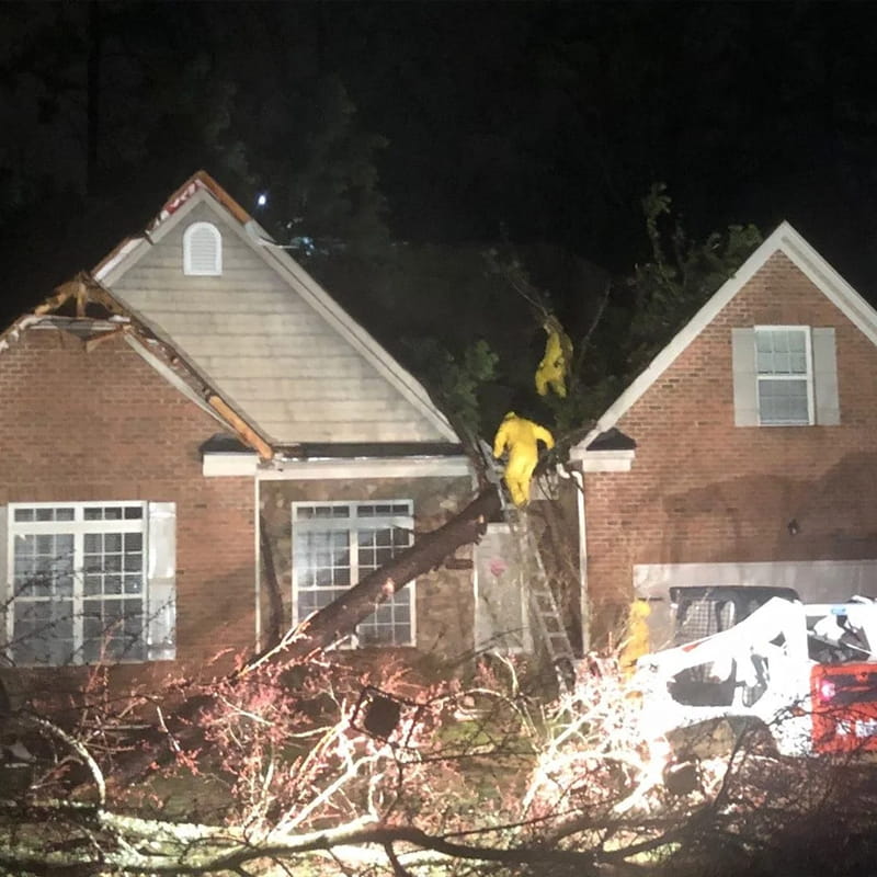 Emergency crew removing tree from roof after storm damage in Charlotte, NC